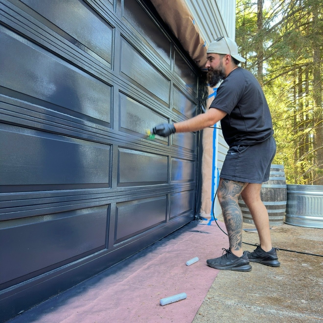 Clark Exteriors professional spray painting a residential garage door